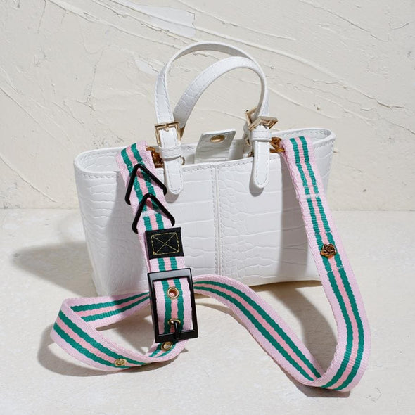 pink bag strap on white leather bag