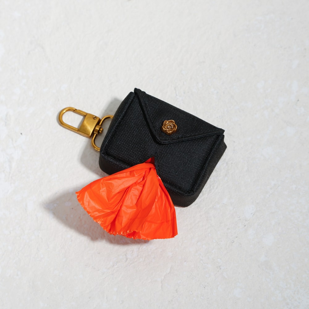 high end poo bag holder with envelope closure and rose hardware gold hook